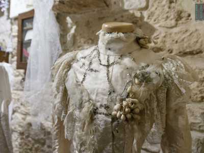 ...e alla sua sinistra un abito dorato da sposa sontuoso, abbellito da perline in pasta di vetro e fiori d�arancio in cera